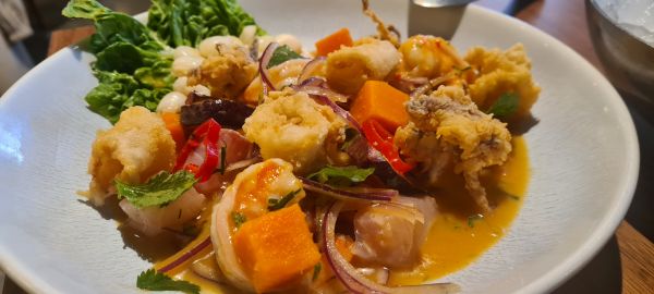 Refrescante y atractivo ceviche mixto de corvina, pulpo, gambas y chipirón frito