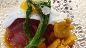 Tartar de atún, huevo de codorniz, patacones, salicornia y salsa de ajíes.